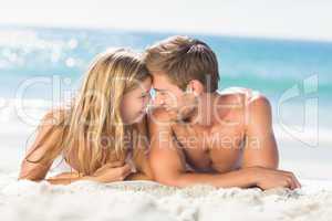 Happy couple relaxing together in the sand