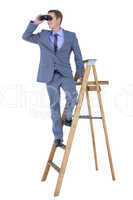 A businessman using binoculars while climbing on a ladder