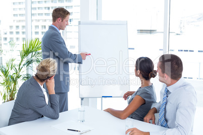 Manager presenting whiteboard to his colleagues
