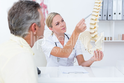 Doctor showing her patient a spine model