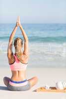 Fit woman doing yoga beside the sea