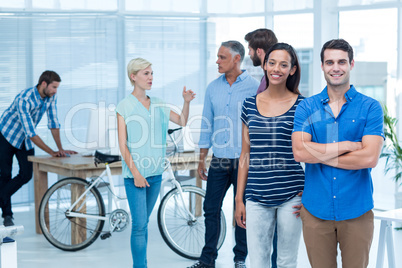 Happy business friends standing with arms crossed