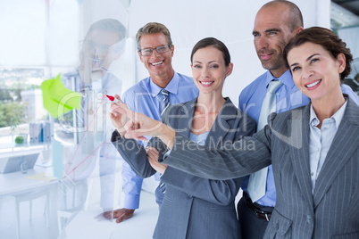 Businesswoman drawing graph on the board