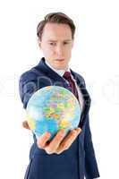 Serious businessman holding terrestrial globe