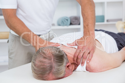 Physiotherapist doing shoulder massage to his patient