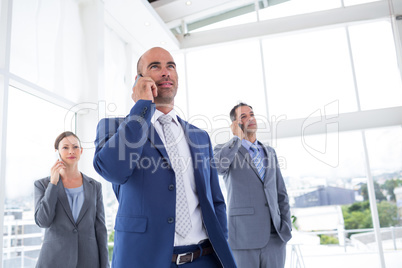 Business colleagues using phones