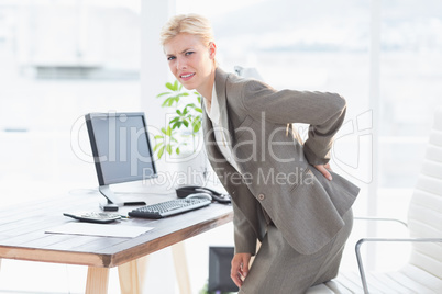 Sad businesswoman having back pain