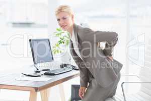 Sad businesswoman having back pain