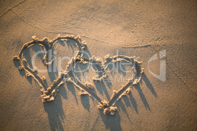 two hearts drawn in the sand