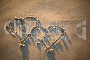 two hearts drawn in the sand