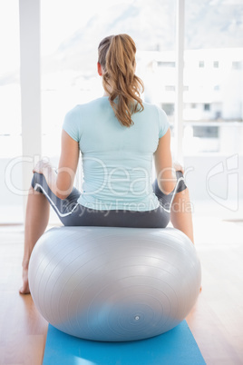 Woman sitting on exercise ball Woman sitting on exercise ball