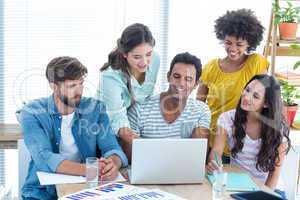 Colleagues using laptop at office