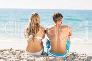 Happy couple relaxing together in the sand