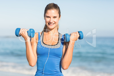 Beautiful fit woman holding dumbbells