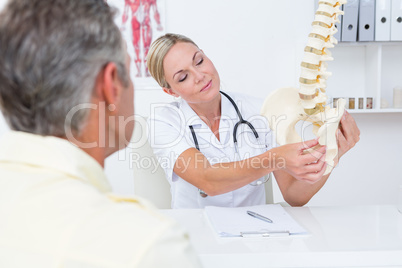 Doctor showing her patient a spine model