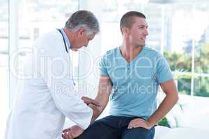 Doctor examining his patients arm