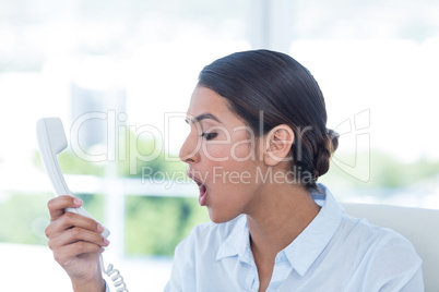 Businesswoman yelling at her phone Businesswoman yelling at her phone