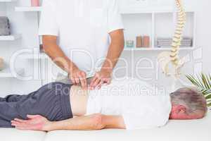 Physiotherapist doing back massage to his patient