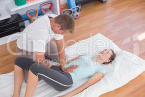 Woman stretching with her trainer