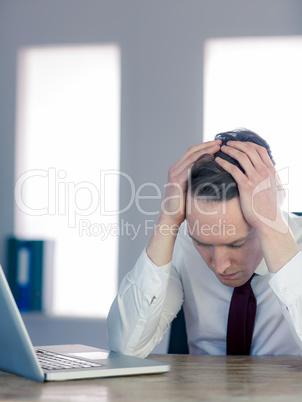 Worried businessman with head in hands