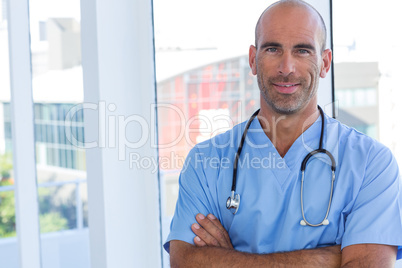 Confident male doctor looking at camera with arms crossed