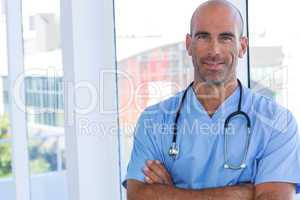 Confident male doctor looking at camera with arms crossed