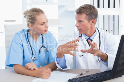 Concentrated doctor and nurse speaking in medical office