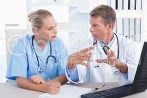 Concentrated doctor and nurse speaking in medical office