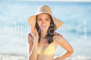Brunette relaxing with a straw hat smiling at camera