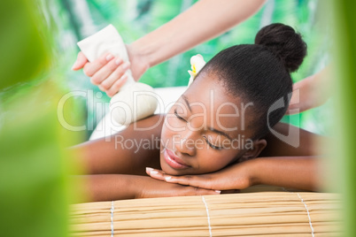 Pretty woman enjoying a herbal compress massage