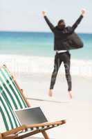 Happy businessman cheering at the beach