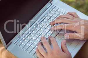 Young man using laptop in the park