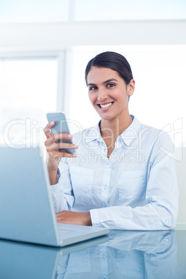 Smiling businesswoman using her smartphone