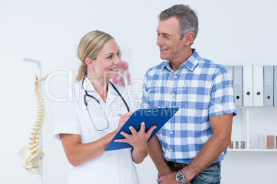 Doctor showing clipboard to her patient