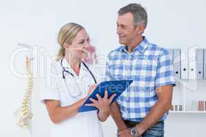 Doctor showing clipboard to her patient
