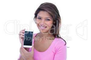 Pretty brunette smiling at camera and holding a smartphone