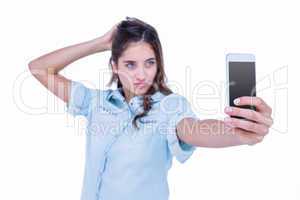 Pretty brunette taking a selfie with smartphone