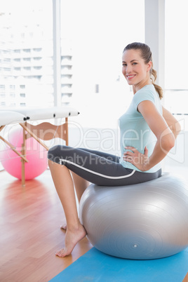 Woman sitting on exercise ball Woman sitting on exercise ball
