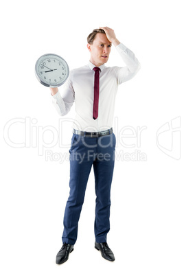 Anxious businessman holding a clock