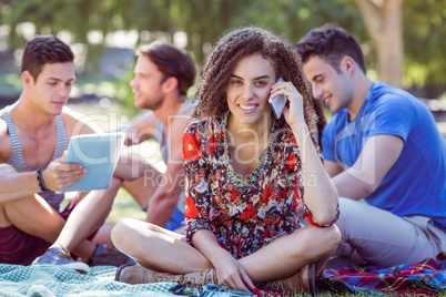 Cute curly hair girl on the phone in the park