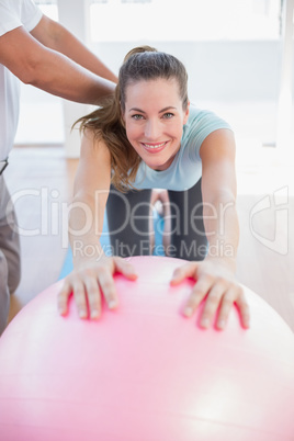 Trainer with woman on exercise ball