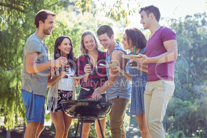 Happy friends in the park having barbecue