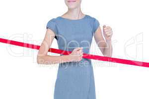 Happy businesswoman cutting red ribbon