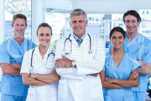 Team of doctors standing arms crossed and smiling at camera