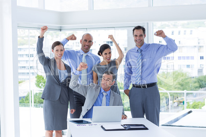 Smiling business team celebrating and looking at camera