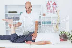 Physiotherapist doing leg massage to his patient