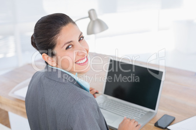 Smiling businesswoman using her computer