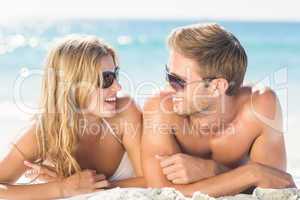 Happy couple relaxing together in the sand