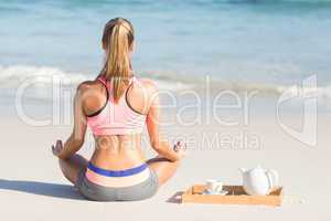 Fit woman doing yoga beside the sea