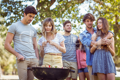 Happy friends in the park having barbecue